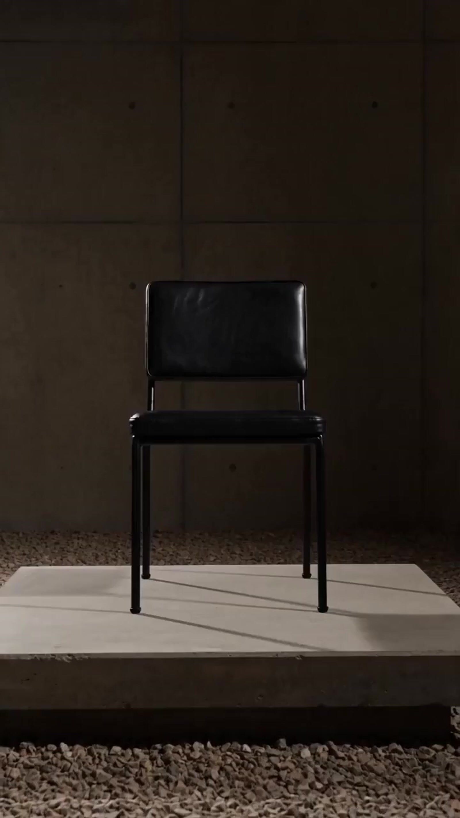 a black chair sitting on top of a white platform