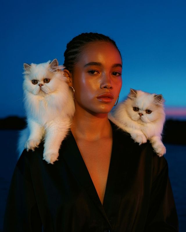 a woman with two cats on her shoulders