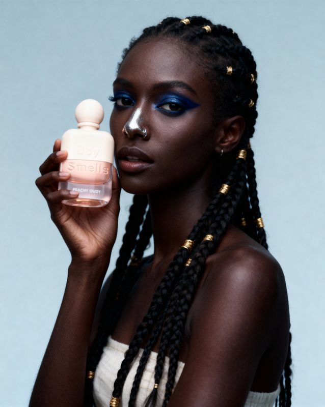 a woman holding a bottle of perfume in her hand