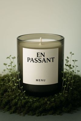 a candle sitting on top of a moss covered ground