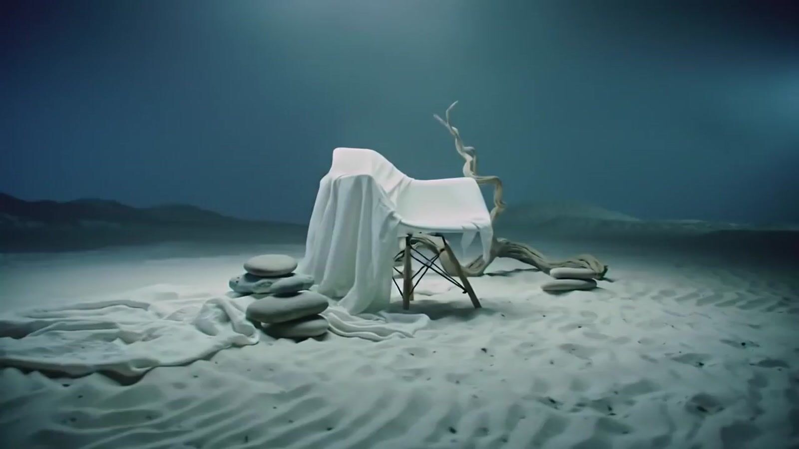 a chair covered in a sheet on top of a sandy beach