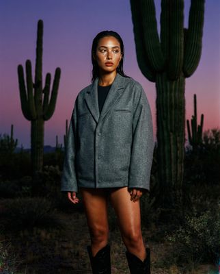 a woman standing in front of a cactus