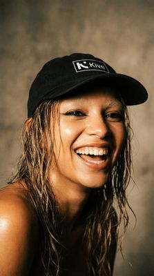 a woman with wet hair wearing a black hat