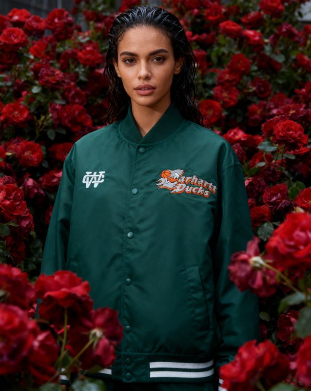a woman standing in front of red flowers