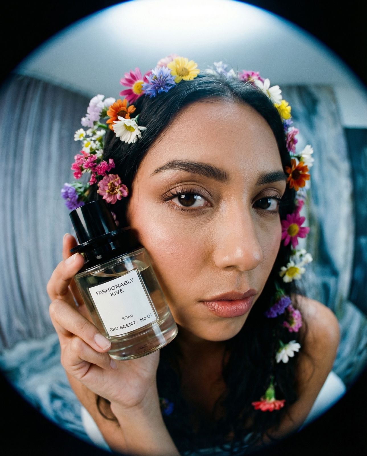 a woman holding a bottle of perfume in front of her face