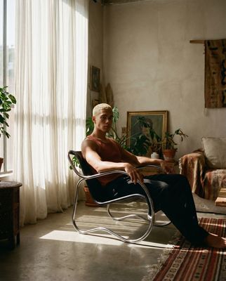 a man sitting in a chair in front of a window