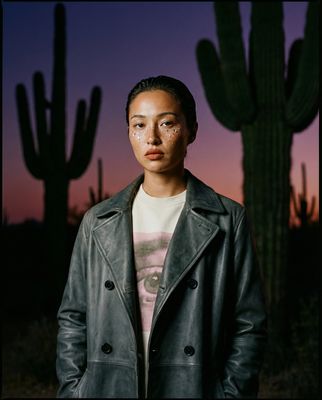a woman standing in front of a cactus
