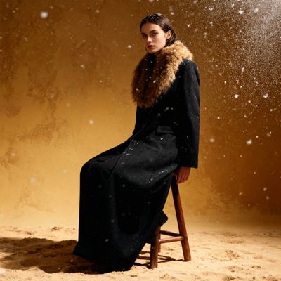 a woman sitting on a stool in the snow