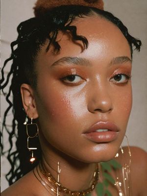 a close up of a person wearing a necklace and earrings