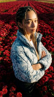 a woman standing in a field of red flowers