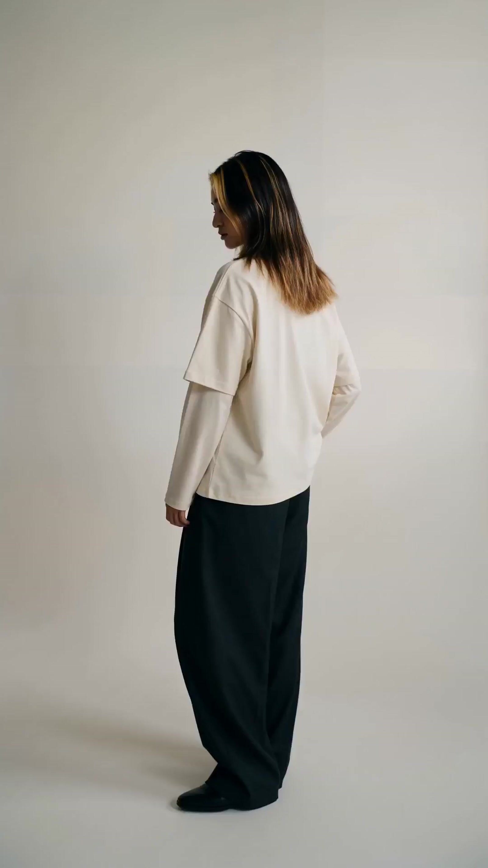 a woman in a white shirt and black pants