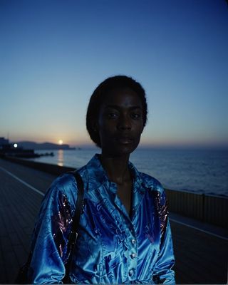 a woman standing on a pier next to the ocean