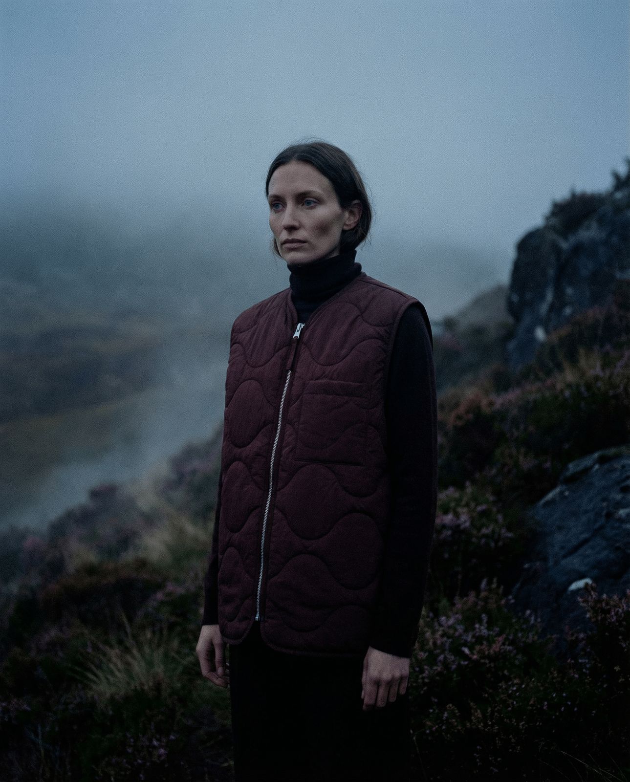 a woman standing on a hill in the fog