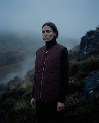 a woman standing on a hill in the fog