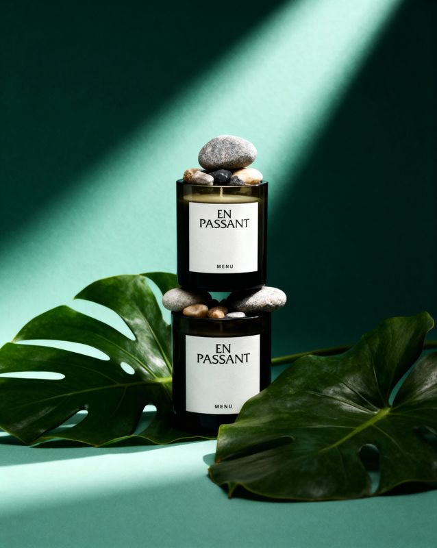 a bottle of perfume sitting on top of a green plant