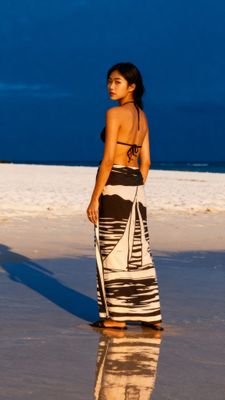 a woman standing on a beach next to the ocean