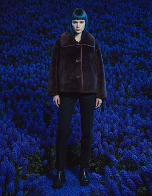 a woman standing in a field of blue flowers