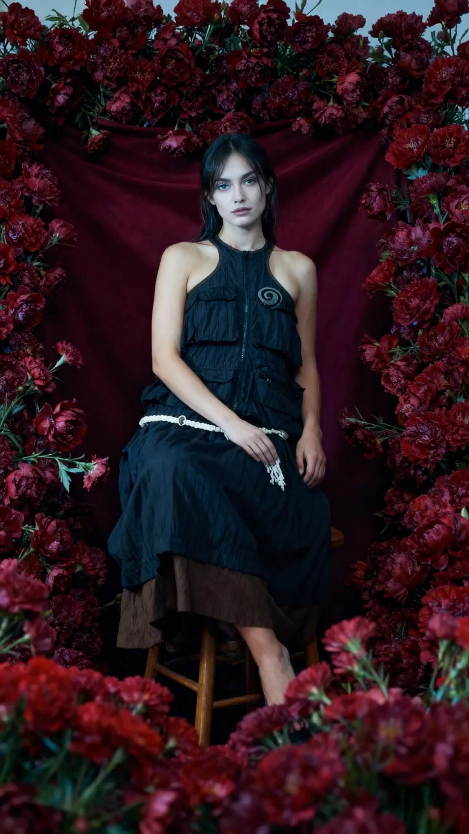 a woman sitting in a chair surrounded by flowers