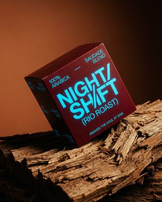 a box of night shift pro roast sitting on top of a pile of wood