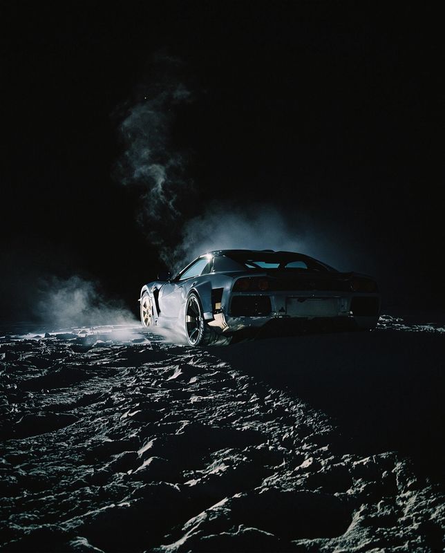 a car driving on a snowy road at night