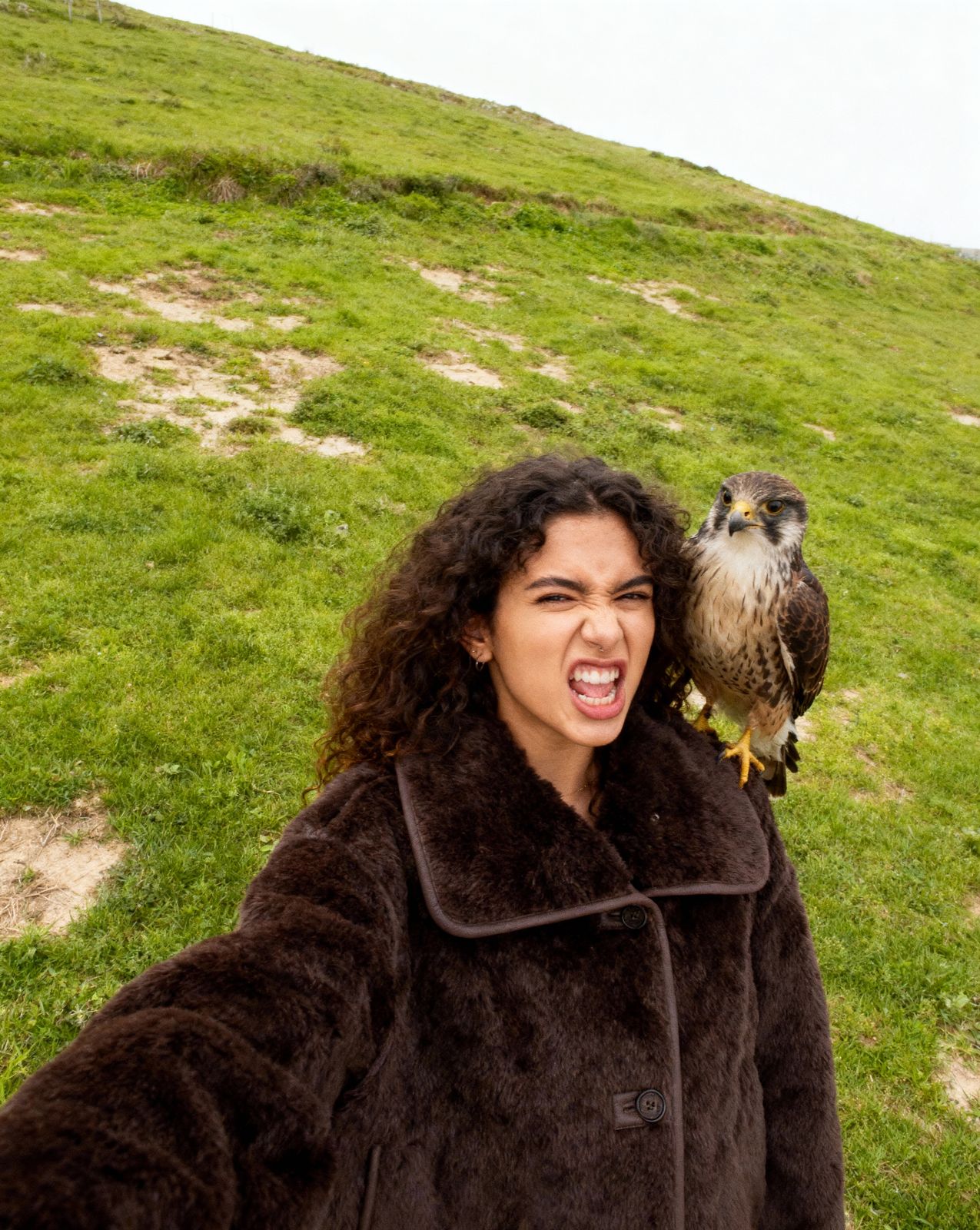 a woman holding an owl on her arm