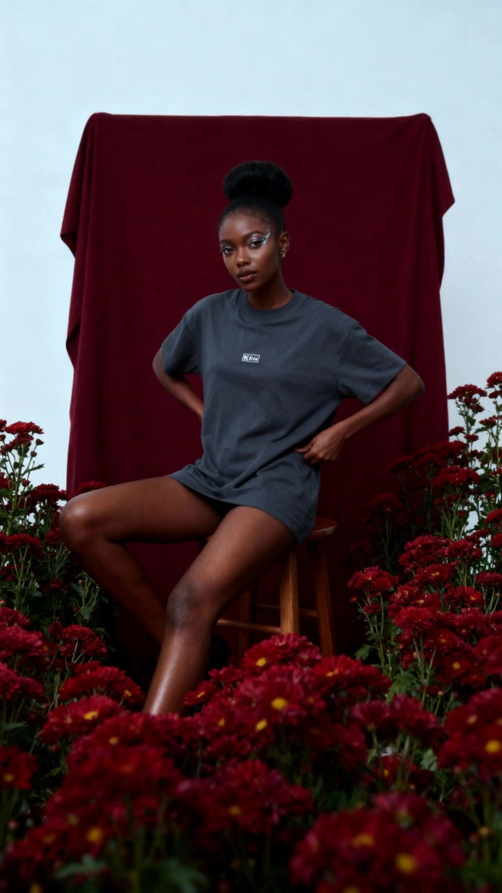 a woman sitting on a chair in a field of flowers