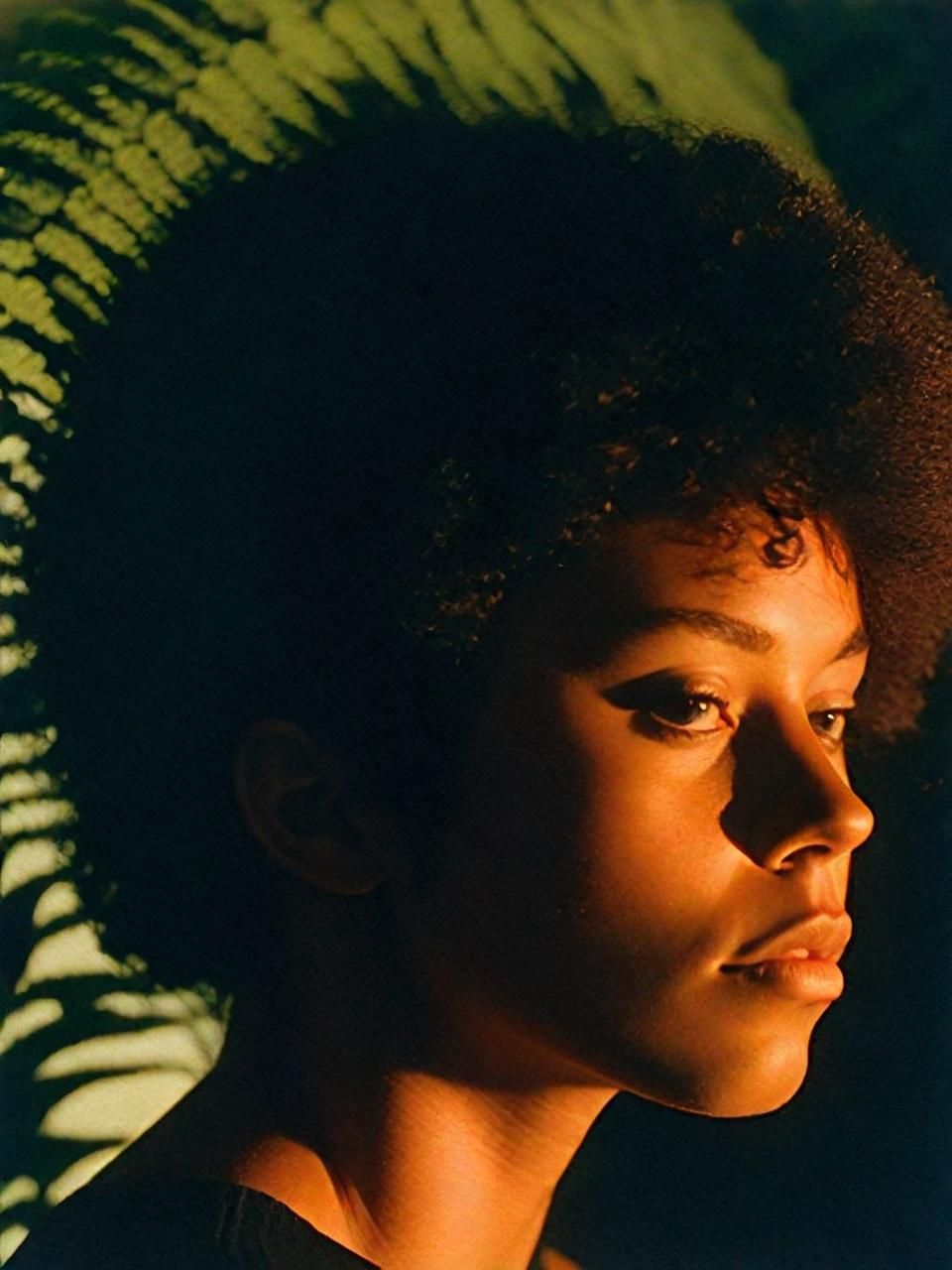 a young man with an afro is looking off into the distance