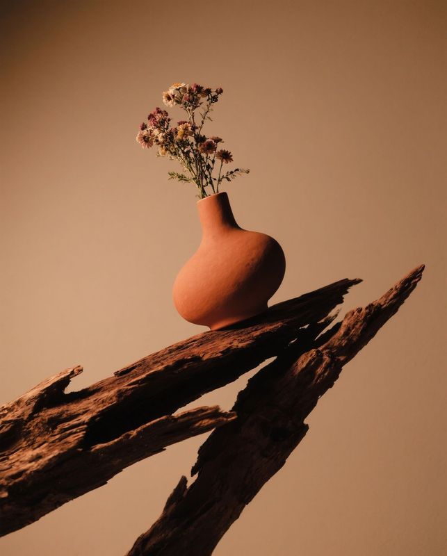 a vase with flowers in it sitting on a branch