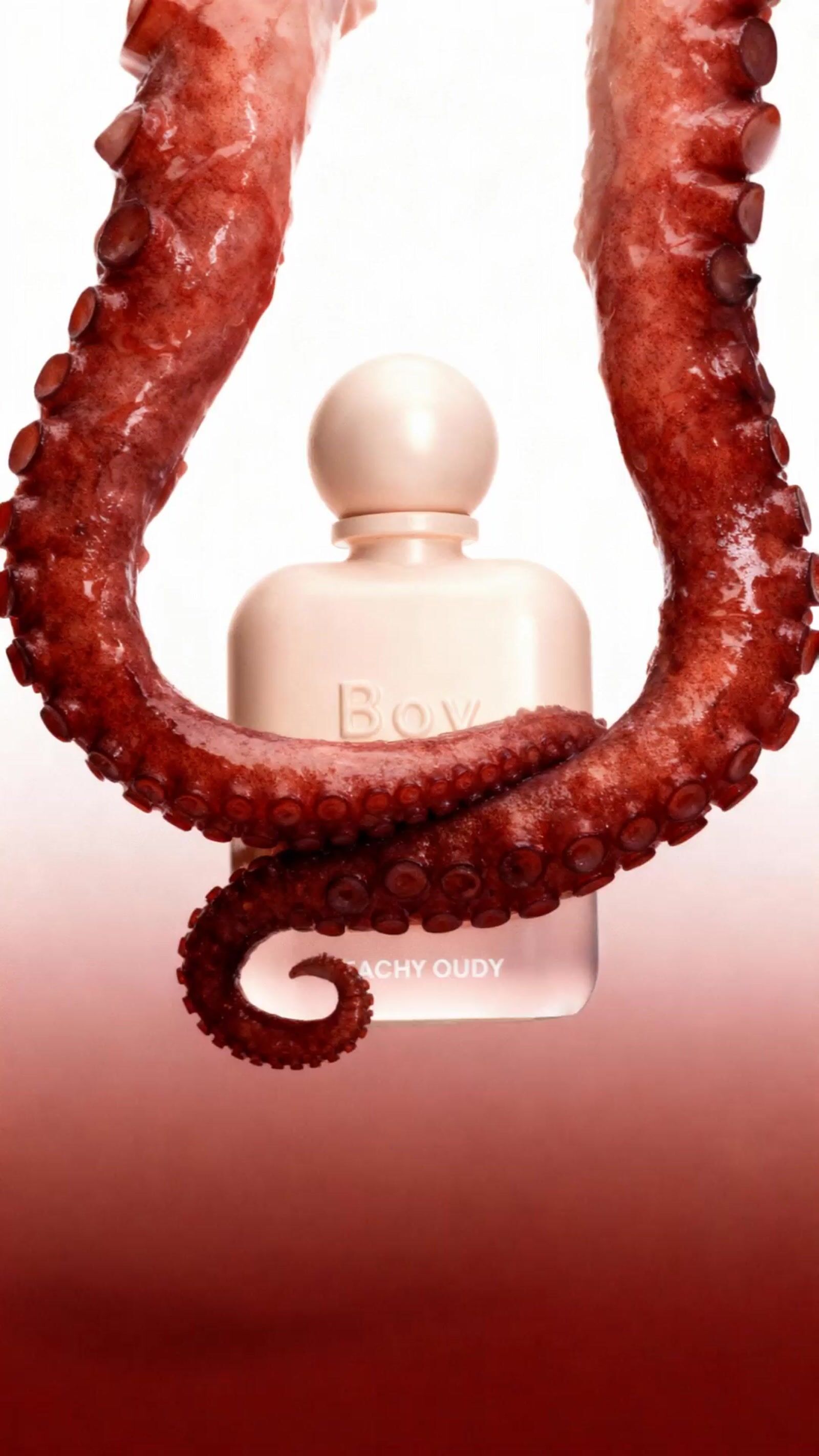 an octopus with a bottle of perfume in its mouth