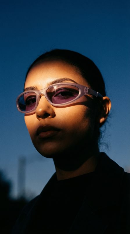a woman wearing pink sunglasses and a black shirt