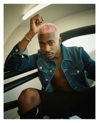 a man with a pink mohawk sitting down