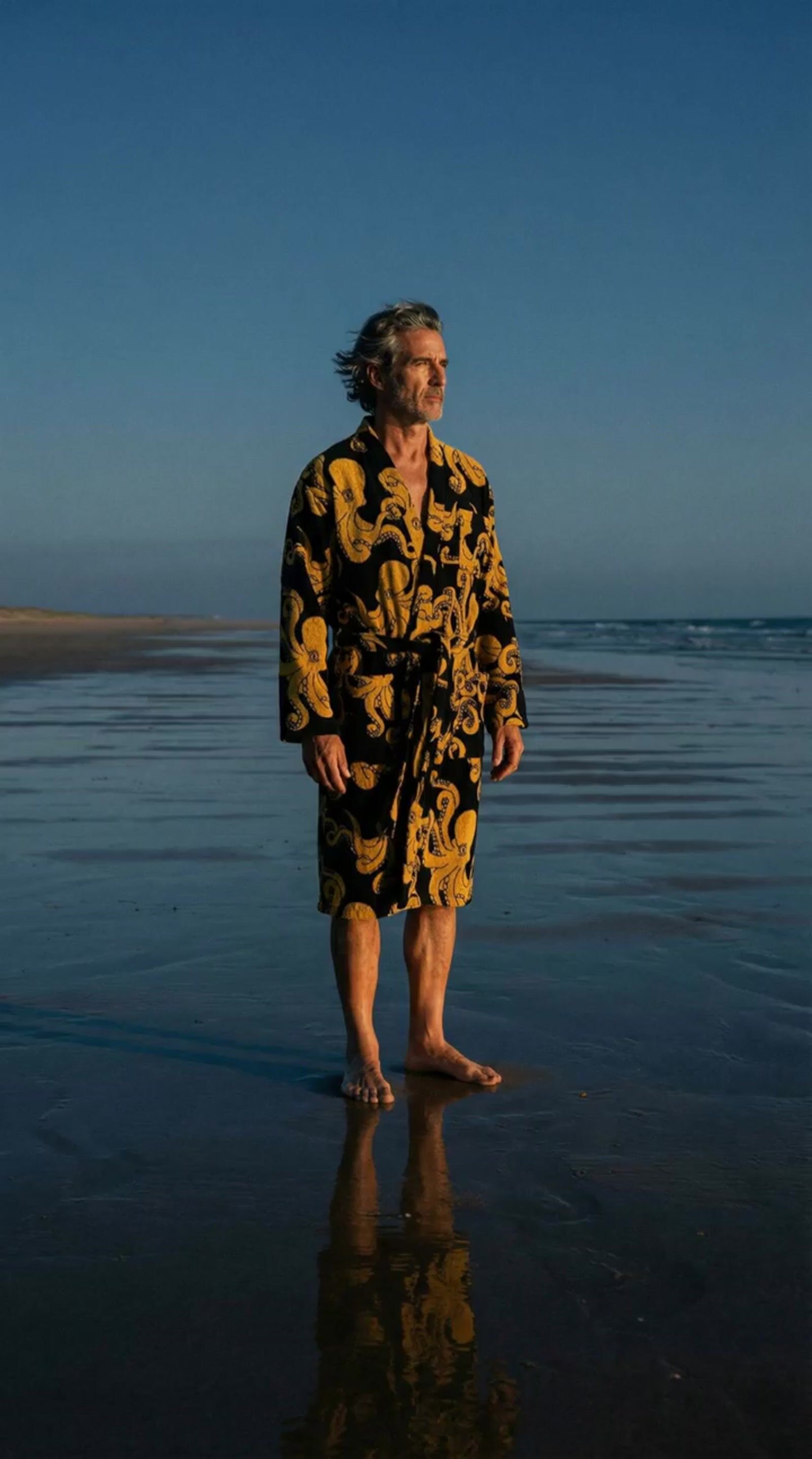 a man standing on a beach next to the ocean