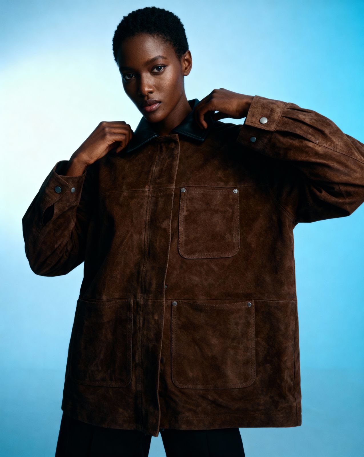 a woman in a brown jacket posing for a picture