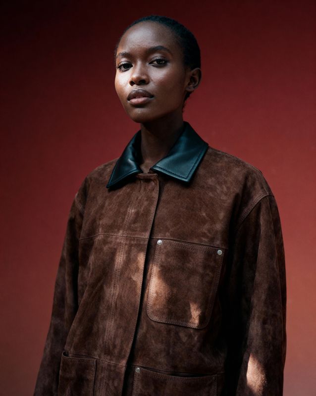 a woman standing in front of a red wall