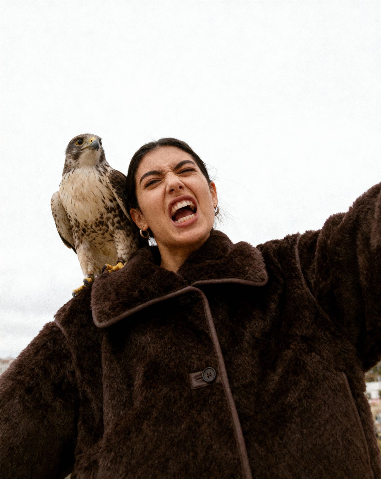 a woman holding a bird on her shoulders