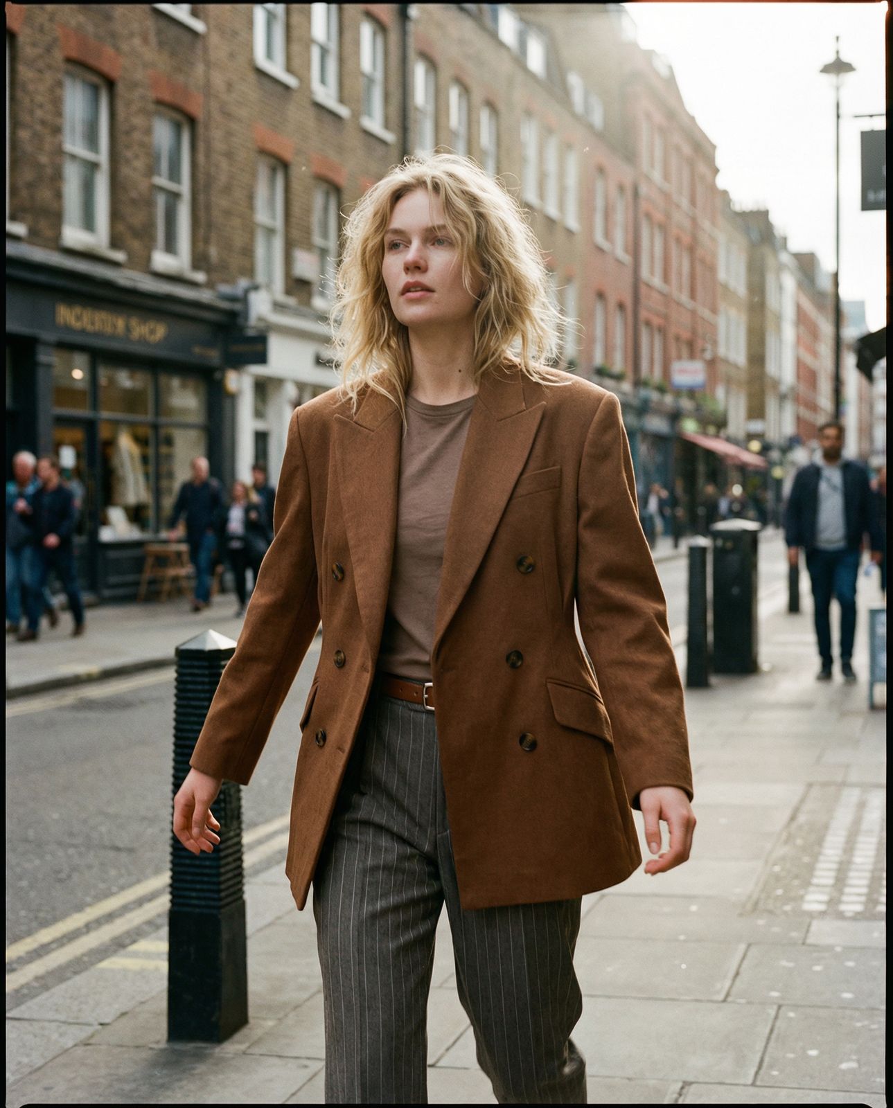 a woman walking down a street next to a tall building