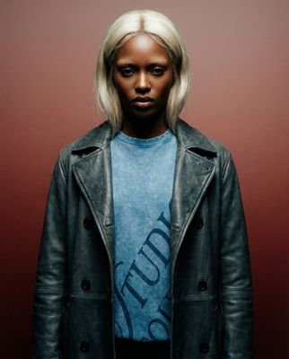 a woman with blonde hair wearing a black leather jacket