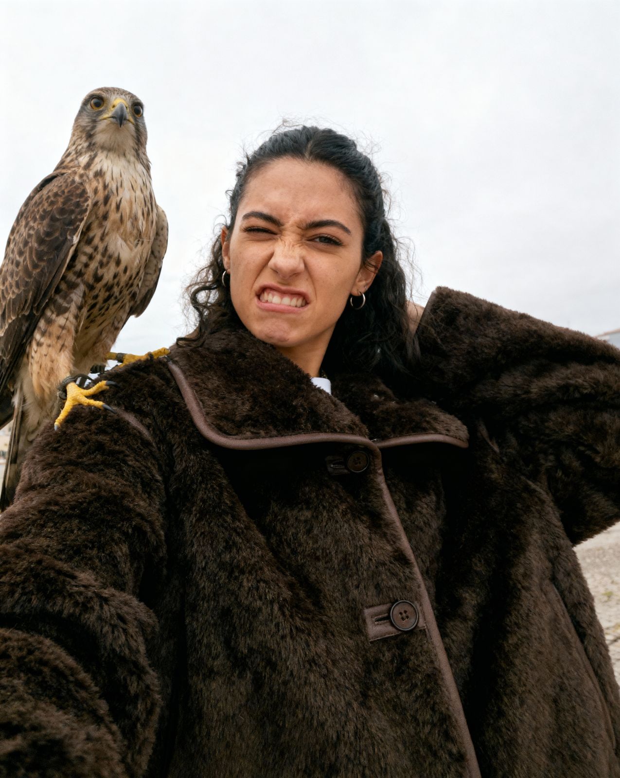a woman holding a falcon on her arm