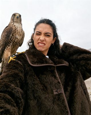a woman holding a falcon on her arm