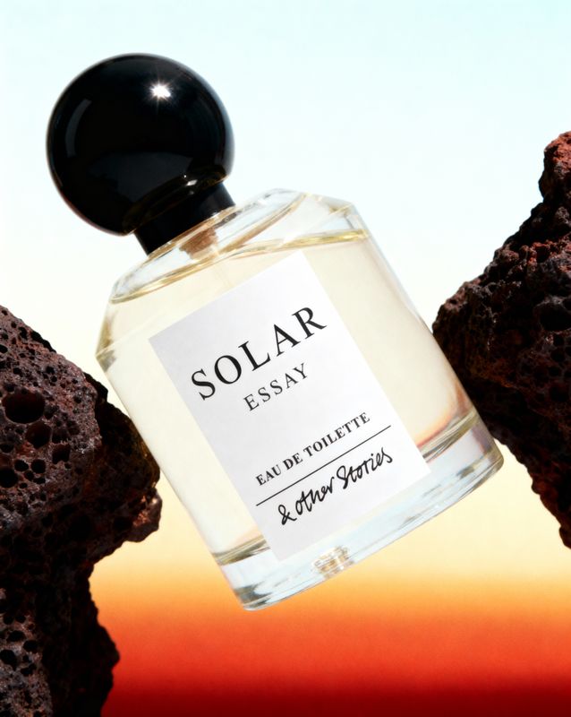 a bottle of perfume sitting on top of a rock