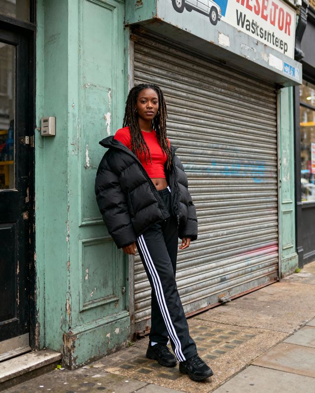a woman leaning against a door in front of a store