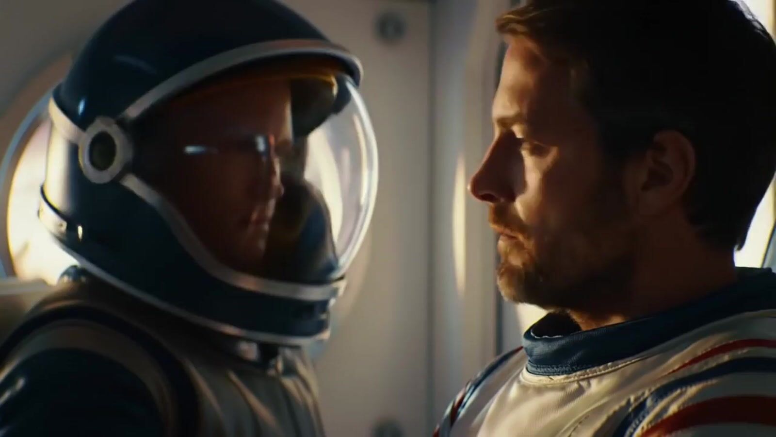 a man in a space suit looking at another man in a space suit