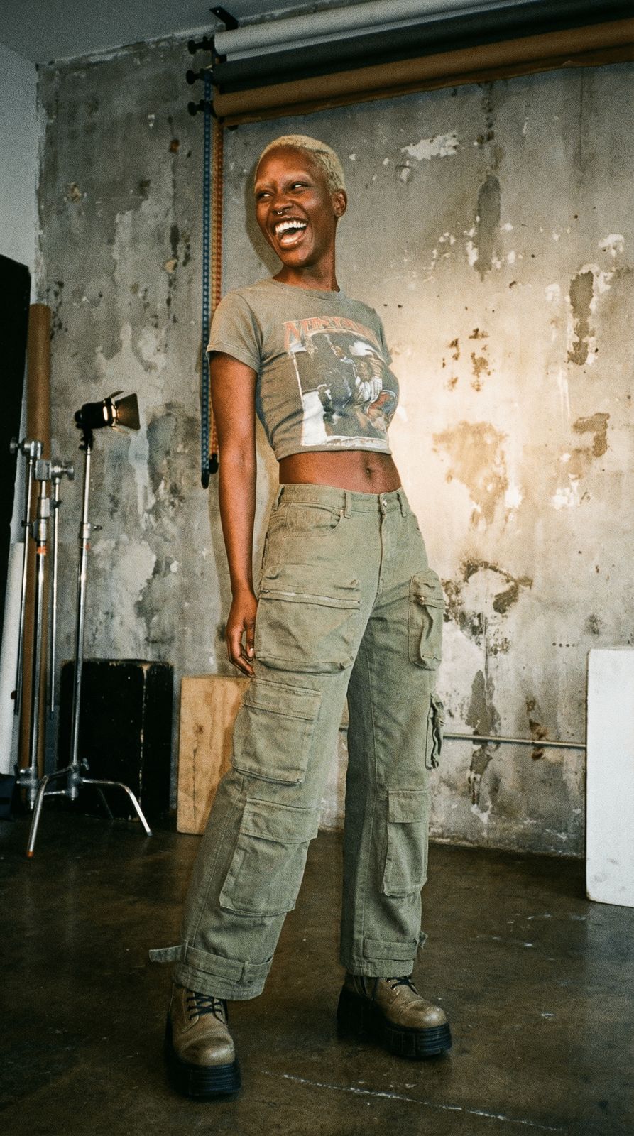 a woman standing in front of a wall with a smile on her face