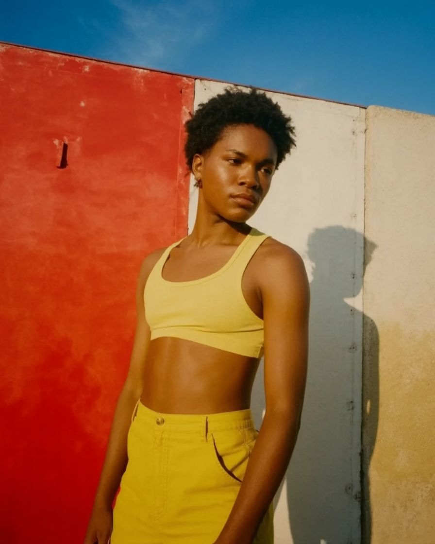 a woman standing in front of a red and white wall