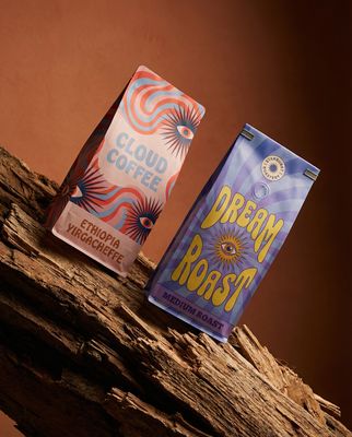 a couple of bags of coffee sitting on top of a tree branch