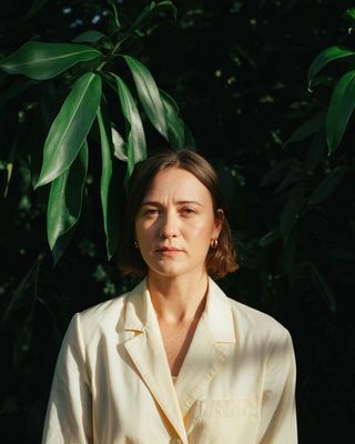 a woman standing in front of a tree