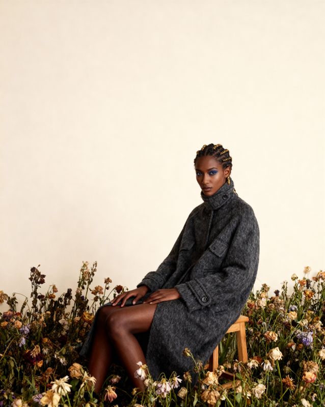 a woman sitting on a chair in a field of flowers