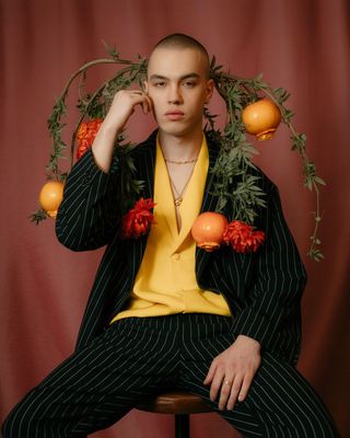 a man in a suit sitting on a stool