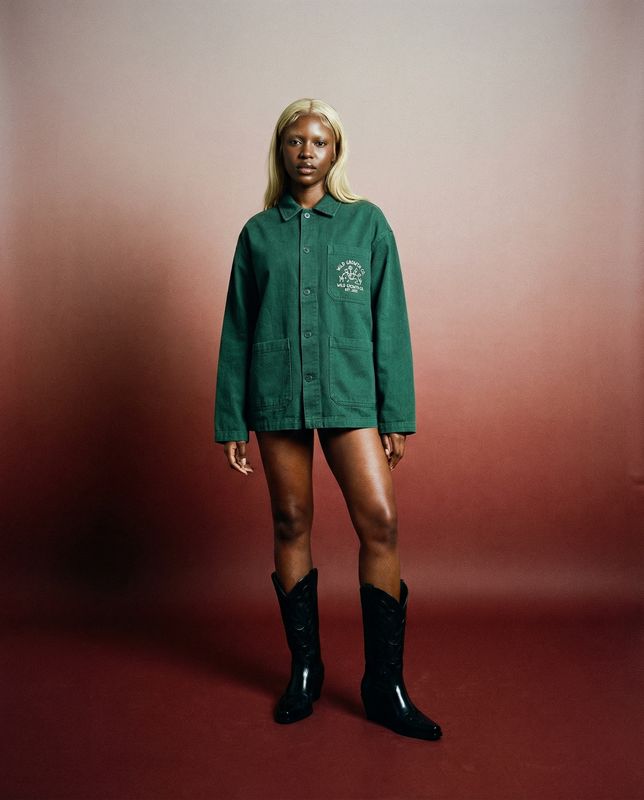 a woman in a green shirt and black boots