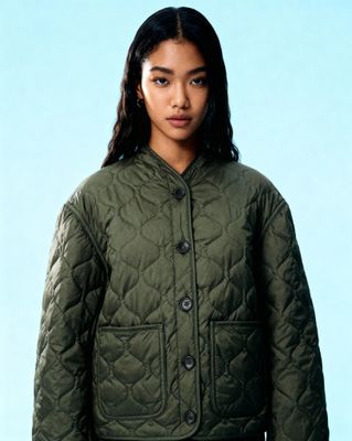a woman wearing a green quilted jacket